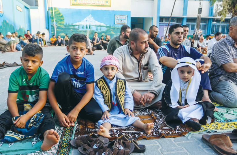 MEN AND boys attend a prayer in July to mark the Muslim holiday of Eid al-Adha, at an UNRWA school in Rafah, in the southern Gaza Strip.  (photo credit: ABED RAHIM KHATIB/FLASH90)