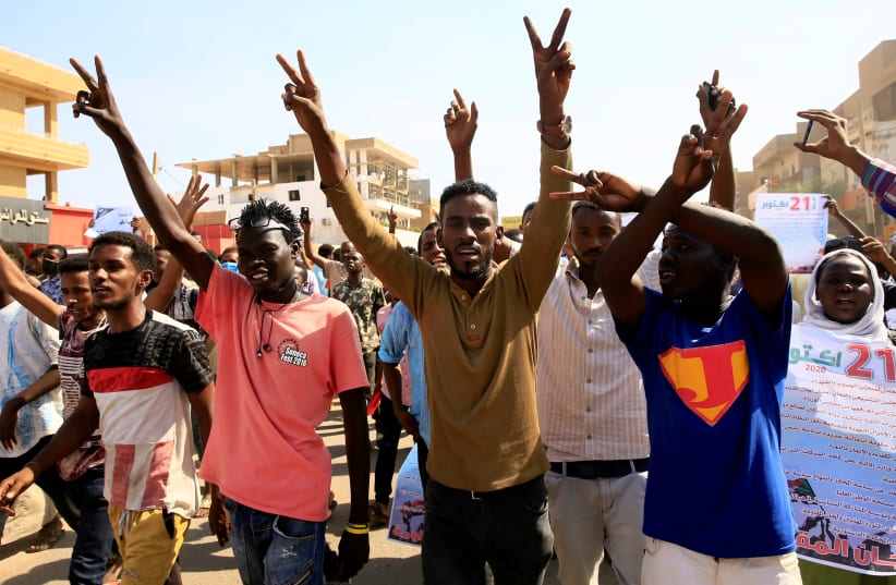 Sudanese protesters chant slogans as they gather ahead of a rally to put pressure on the government to improve conditions and push ahead with reform in Khartoum, Sudan October 21, 2020. (photo credit: REUTERS/ MOHAMED NURELDIN ABDALLAH)