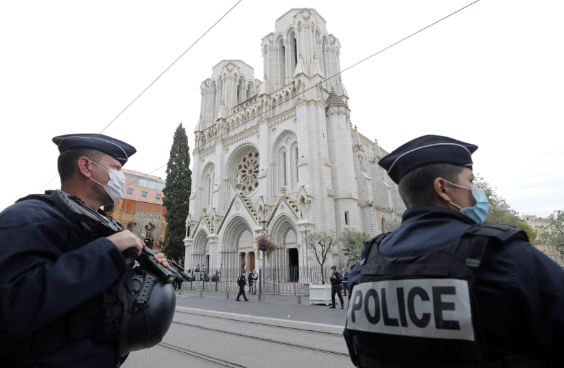 Police officers stand guard at the scene of a reported knife attack at Notre Dame church in Nice, France, October 29, 2020. (photo credit: ERIC GAILLARD/REUTERS)