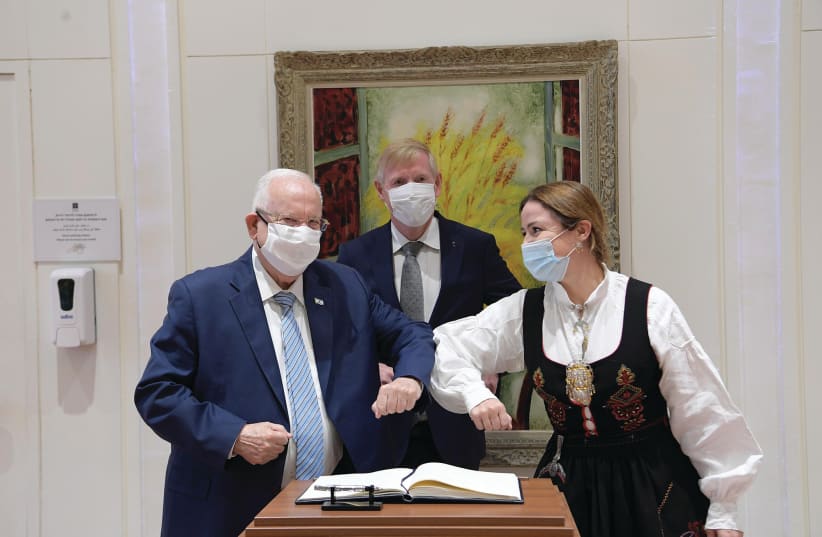 PRESIDENT REUVEN Rivlin stands next to Swedish Ambassador Erik Ullenhag and his wife, who is dressed in Swedish national costume. (photo credit: AMOS BEN-GERSHOM/GPO)
