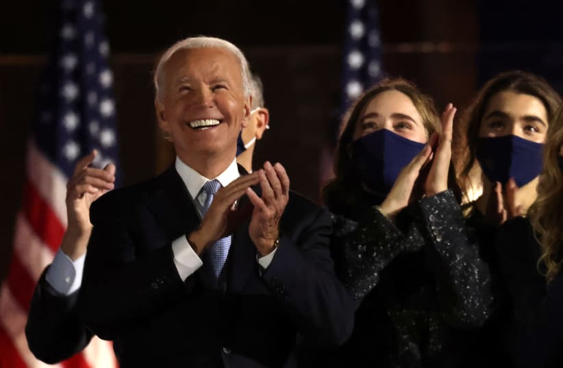 Democratic 2020 U.S. presidential nominee Joe Biden applauds next to his granddaughters after speakig during his election rally, after news media announced that he has won the 2020 U.S. presidential election, in Wilmington, Delaware, U.S., November 7, 2020. (photo credit: JONATHAN ERNST / REUTERS)
