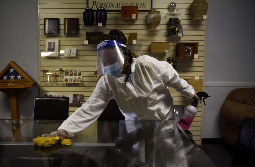 A worker disinfects surfaces to prevent the spread of the coronavirus disease at Beresford Funeral Service in Houston, Texas, US, 2020 (photo credit: REUTERS/CALLAGHAN O’HARE)