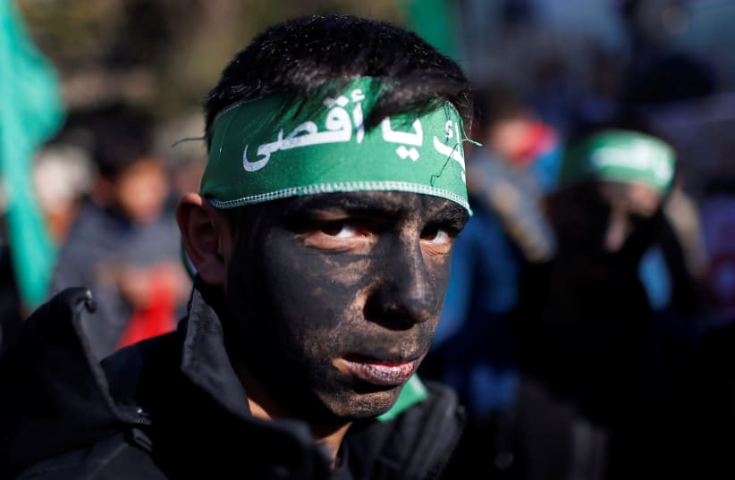 A young Palestinian has his face painted as he looks on during a Hamas rally in Gaza January 3, 2020 (photo credit: REUTERS/MOHAMMED SALEM)