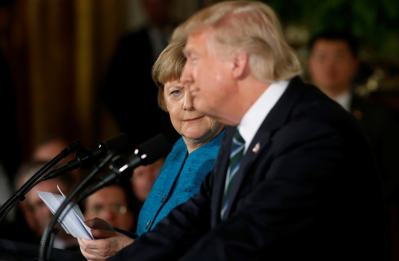 Germany's Chancellor Angela Merkel (L) gives US President Donald Trump a look after he suggested they might have something in common, as he answered a question about his accusation that he had been wiretapped by former President Barack Obama, during their joint news conference in the East Room of th (photo credit: REUTERS/JONATHAN ERNST)