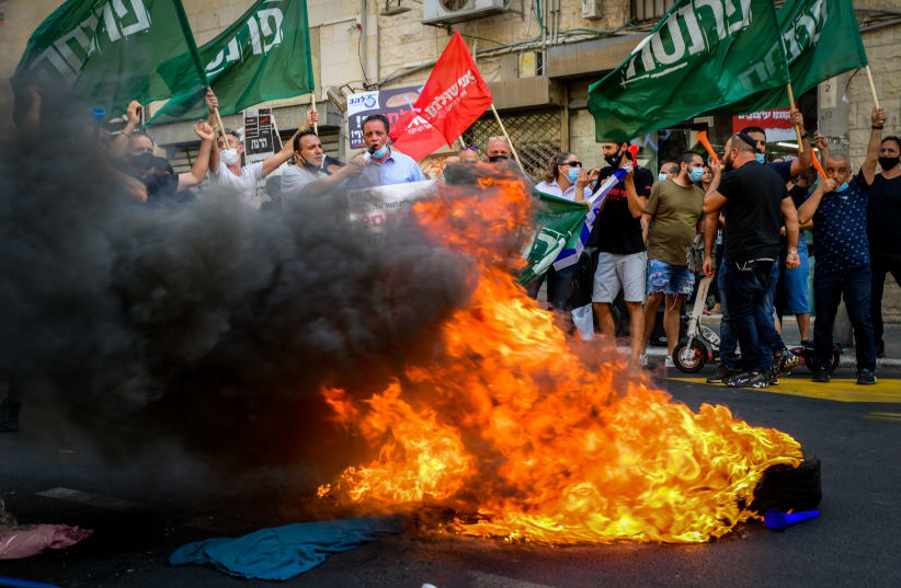 SMALL-BUSINESS owners burn excess stock in protest of corona restrictions, in Tel Aviv on October 29 (photo credit: AVSHALOM SASSONI/FLASH90)