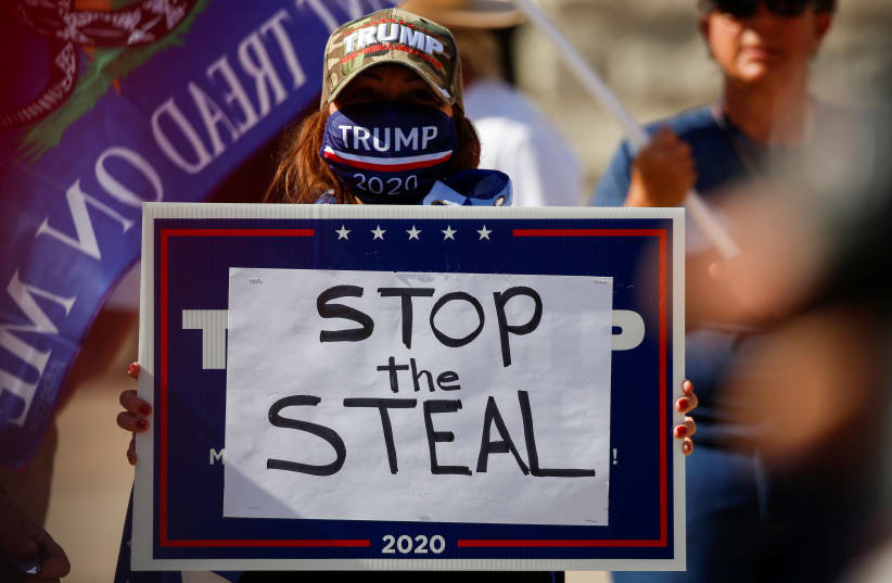 A supporter of President Donald Trump holds a sign during a “Stop the Steal” protest after the 2020 US presidential election was called by the media for Democratic candidate Joe Biden, in front of the Arizona State Capitol in Phoenix, Arizona, US, November 7, 2020 (photo credit: REUTERS/JIM URQUHART)