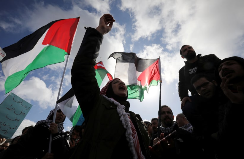 Protesters hold Jordanian and Palestinian flags and shout slogans during a protest against U.S. President Donald Trump's proposed Middle East peace plan, near the U.S. Embassy in Amman, Jordan, January 31, 2020. (photo credit: REUTERS)