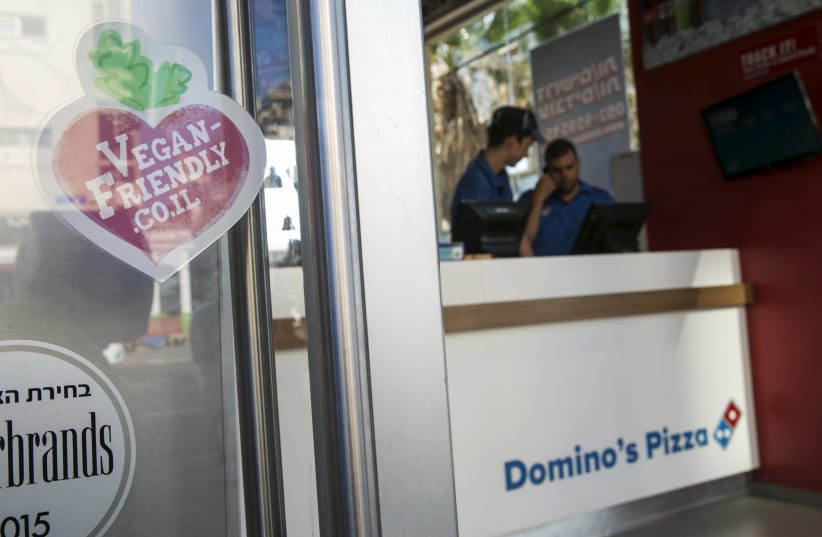 A vegan friendly sticker in seen on the door of a Domino's Pizza restaurant in Tel Aviv (photo credit: BAZ RATNER/REUTERS)