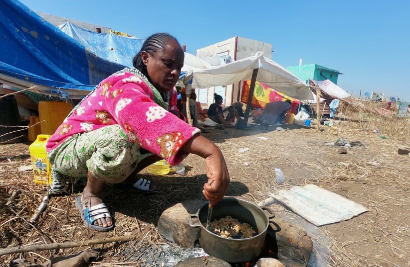 An Ethiopian who fled the ongoing fighting in Tigray region, prepares a meal in Hamdait village on the Sudan-Ethiopia border in eastern Kassala state, Sudan November 14, 2020. REUTERS/El Tayeb Siddig (photo credit: REUTERS/EL TAYEB SIDDIG)