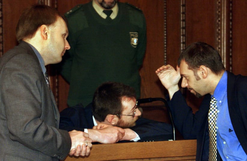 WERNER ARNOLD (center) talks to his attorneys in a courtroom in 1998 in Nuremberg, the site of the Nazi war-crimes trial discussed in the book. Arnold was accused of the rape and murder of an 11-year-old German girl. (photo credit: REUTERS)