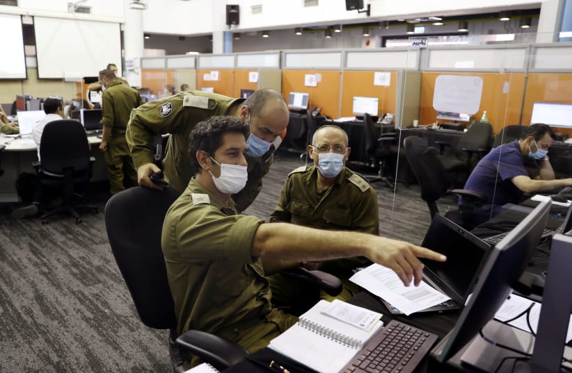Israeli soldiers at the IDF Corona Task Force Headquarters as they conduct epidemiological investigations as part of the army's effort to trace chains of infection to curb the spread of coronavirus, Ramle, Israel, September 17, 2020 (photo credit: RONEN ZVULUN/REUTERS)