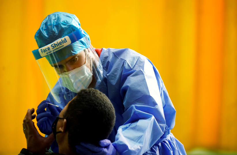A healthcare worker performs a rapid COVID-19 antigen test amid the coronavirus disease (COVID-19) outbreak in Alpedrete, Spain, November 16, 2020.  (photo credit: REUTERS/JUAN MEDINA/FILE PHOTO)