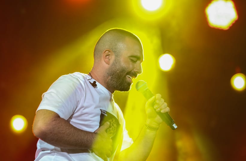 Israeli singer Omer Adam performs live at the annual Kleizmer Festival in the northern Israeli city of Tzfat, on August 14, 2019. (photo credit: DAVID COHEN/FLASH 90)
