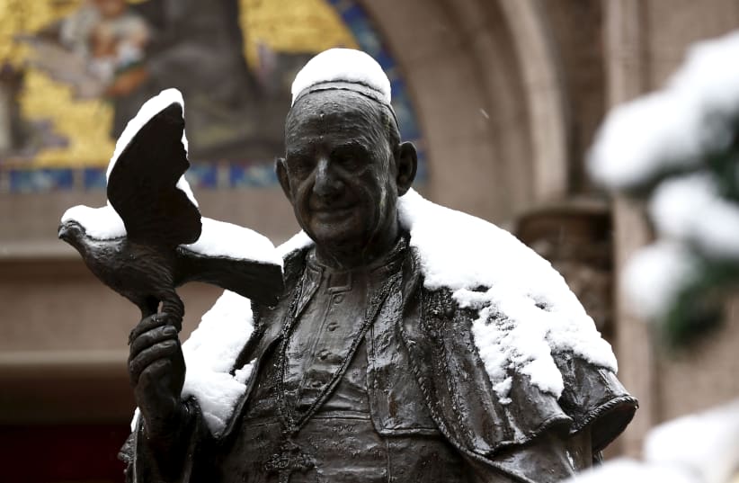 A statue of the late Pope John XXIII is covered by snow at the courtyard of the St. Antuan Catholic church in central Istanbul, Turkey, January 18, 2016. (photo credit: MURAD SEZER/REUTERS)