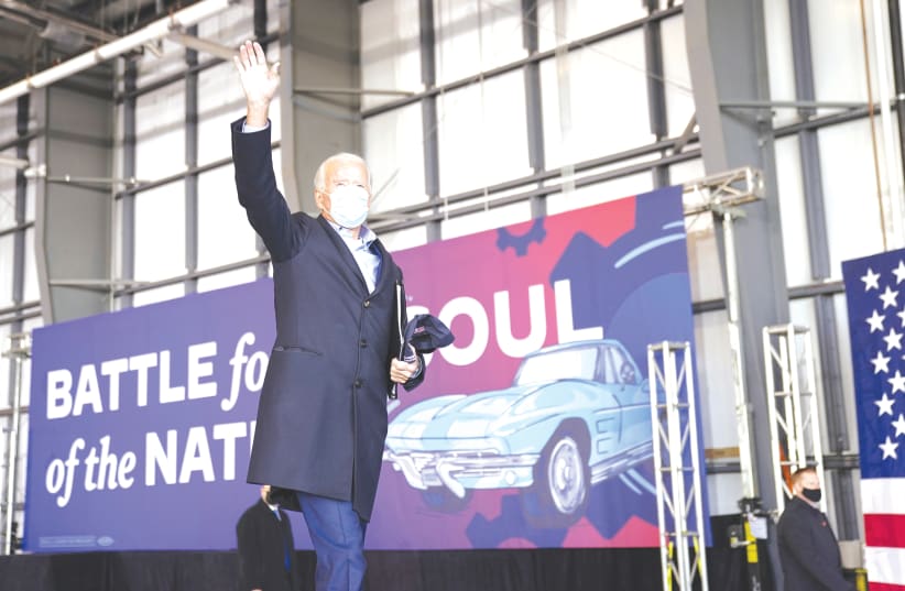 Joe Biden salutes supporters next to the slogan ‘Battle for the soul of the nation’ during a pre-election event in Cleveland, Ohio, on November 2. (photo credit: KEVIN LAMARQUE/REUTERS)