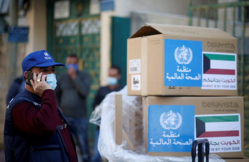 Abdelnaser Soboh, Emergency Health Lead in the World Health Organization's Gaza sub-office, stands next to boxes containing ventilators delivered by the World Health Organization (WHO) and donated by Kuwait, in Gaza City November 29, 2020. (photo credit: REUTERS/MOHAMMED SALEM)