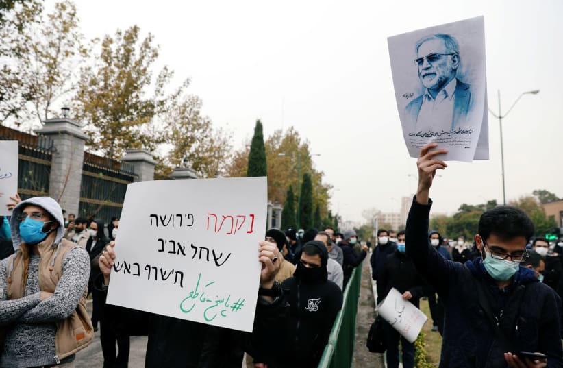 A protester holds a picture of Mohsen Fakhrizadeh, Iran's top nuclear scientist, during a demonstration against his killing in Tehran, Iran, November 28, 2020. (photo credit: MAJID ASGARIPOUR/WANA (WEST ASIA NEWS AGENCY) VIA REUTERS)