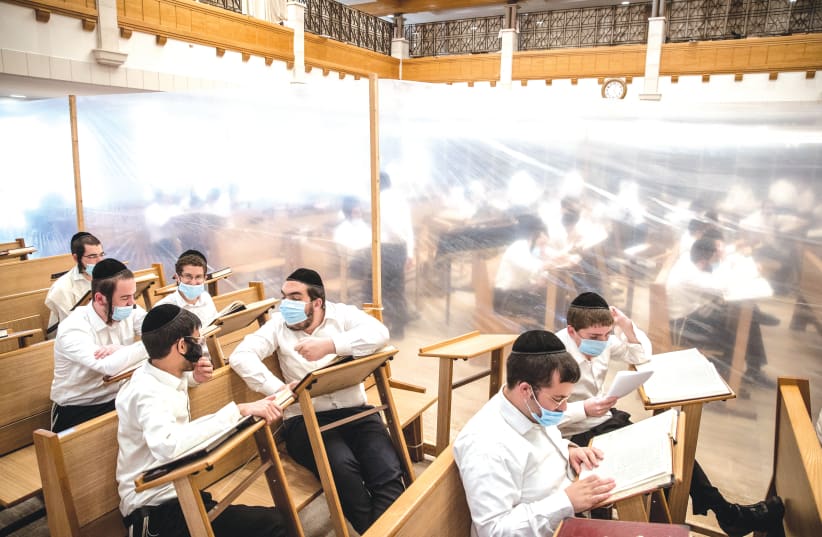 STUDENTS STUDY in separation compartments at the Kamenitz Yeshiva in Jerusalem in September to prevent the spread of COVID-19. (photo credit: YONATAN SINDEL/FLASH 90)