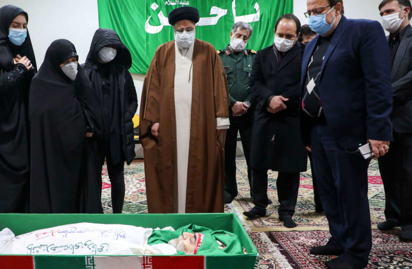 Iran's judiciary chief, Ayatollah Ebrahim Raisi, center, pays respects to the body of slain scientist Mohsen Fakhrizadeh among his family in Tehran, Nov. 28, 2020. (photo credit: MAZAN NEWS AGENCY/AFP VIA GETTY IMAGES)