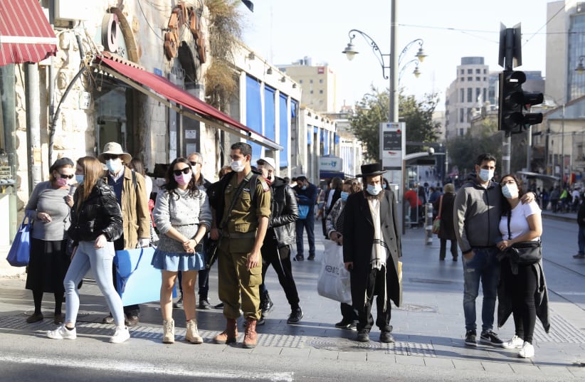 Israelis are seen in Jerusalem wearing masks in accordance with coronavirus restrictions, on December 1, 2020. (photo credit: MARC ISRAEL SELLEM/THE JERUSALEM POST)
