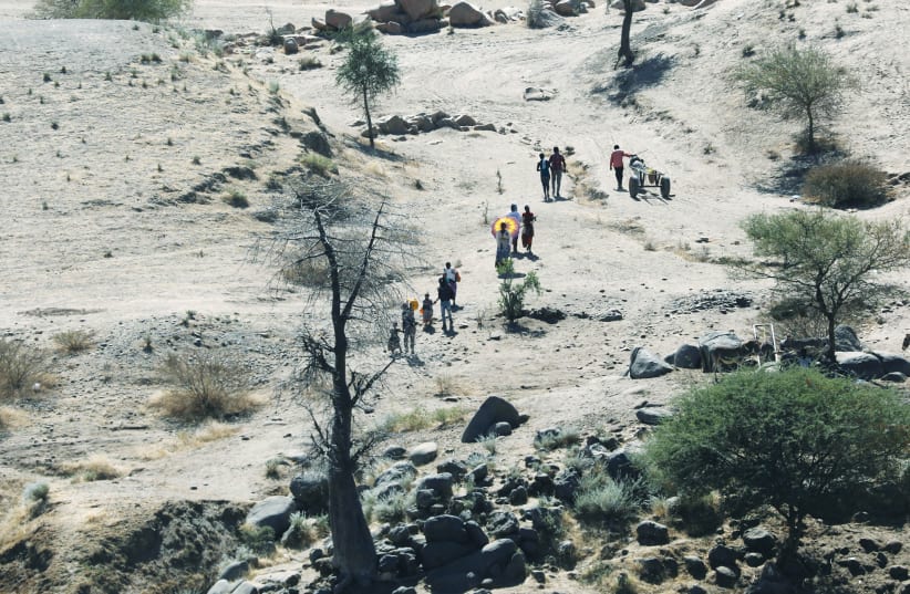 ETHIOPIANS FLEEING from the Tigray region walk toward a river to cross from Ethiopia to Sudan earlier this week. (photo credit: REUTERS)