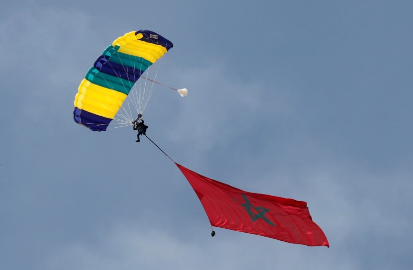 A professional skydiver from Morocco carries the national flag as he flies over the pyramids of Giza during the international event "Jump Like a Pharaoh", amid the coronavirus disease (COVID-19) outbreak, Giza, Egypt, November 8, 2020. (photo credit: AMR ABDALLAH DALSH / REUTERS)