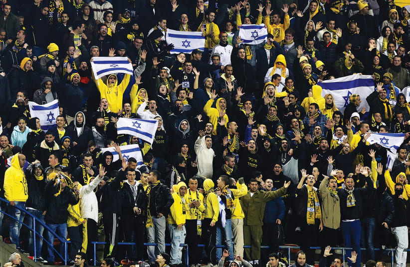 SUPPORTERS OF Beitar Jerusalem cheer for their team during a soccer match against Maccabi Umm el-Fahm  at Teddy Stadium in Jerusalem. (photo credit: NIR ELIAS / REUTERS)