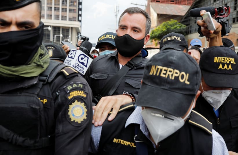 Former Guatemalan Infrastructure Minister Alejandro Sinibaldi is escorted by members of Interpol after turning himself in to face corruption charges, in Guatemala City, Guatemala August 24, 2020. (photo credit: REUTERS)