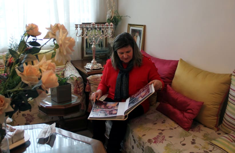 Suzanne Harroch, a Moroccan Jewish singer from Rabat, looks through a photo album during an interview with Reuters at her home in Rabat, Morocco December 11, 2020.  (photo credit: REUTERS/SHEREEN TALAAT)
