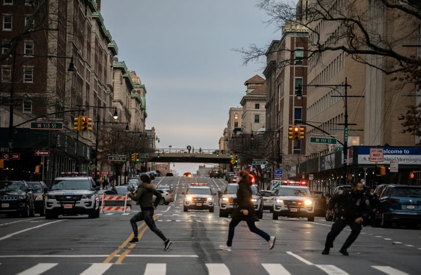 People run after a man opened fire outside the Cathedral Church of St. John the Divine in the Manhattan borough of New York City, New York, US, December 13, 2020. (photo credit: JEENAH MOON/REUTERS)