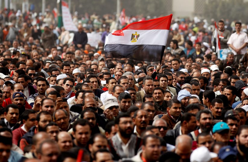 A man holds an Egyptian flag during a rally at Tahrir Square, in Cairo February 25, 2011 (photo credit: REUTERS/PETER ANDREWS)