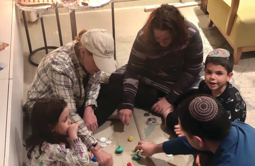 A great miracle happened here: families actually sit and play dreidel together! (photo credit: STEWART WEISS)