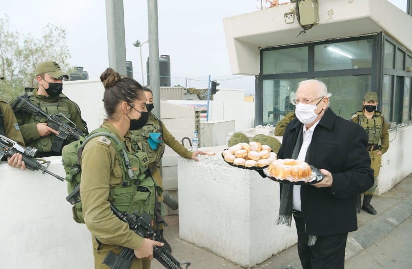 PRESIDENT REUVEN RIVLIN brings donuts and an orange cake made according to the recipe of his late wife, Nechama, to soldiers at Metzukei Dragot. (photo credit: AMOS BEN-GERSHOM/GPO)