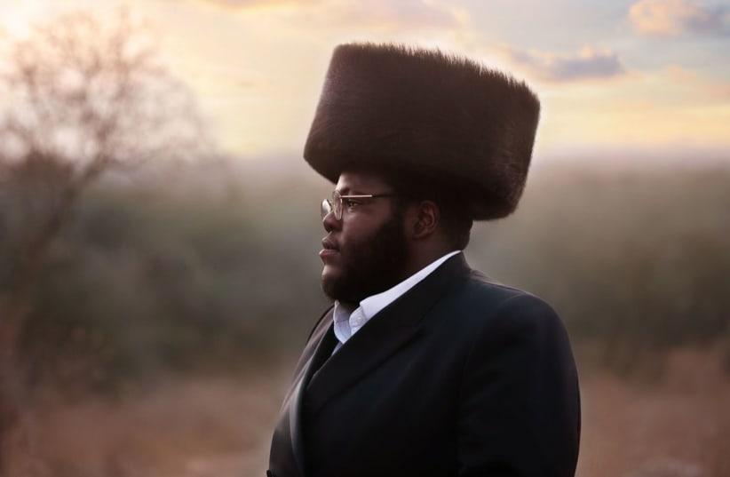 Nissim Black in a field wearing traditional Hasidic garb. (Tziporah Litman/Courtesy of Black) (photo credit: NISSIM BLACK)