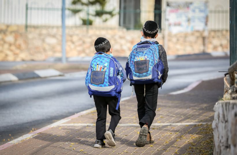 Israeli children wearing face masks make their way to school in Tzfat on their first day back to classes on November 1, 2020 (photo credit: DAVID COHEN/FLASH 90)