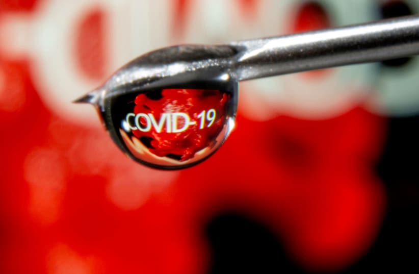 The word "COVID-19" is reflected in a drop on a syringe needle in this illustration taken November 9, 2020.  (photo credit: REUTERS/DADO RUVIC/ILLUSTRATION/FILE PHOTO)