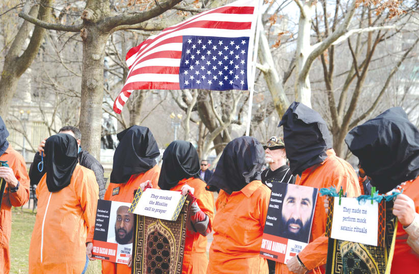 DEMONSTRATORS IN prison jumpsuits and black hoods call for the closure of the Guantanamo Bay detention camp, in a protest near the White House in January.  (photo credit: MIKE THEILER/REUTERS)
