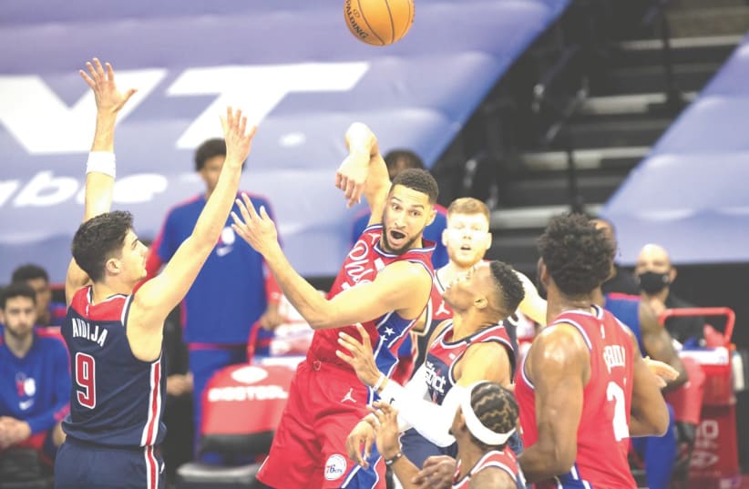 DENI AVDIJA (left) defends against Philadelphia 76ers guard Ben Simmons in his NBA debut for the Washington Wizards late Wednesday night in a game the Sixers won 113-107. (photo credit: REUTERS)