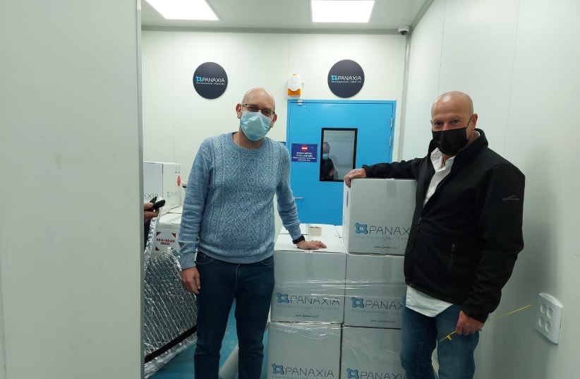 Assi Rotbart, Chief Business Officer and Director at Panaxia, stands with Yuval Landschaft, the director of the Healthy Ministry's Medical Cannabis Unit alongside Israel's first commercial export of medical cannabis products to Germany. (photo credit: PANAXIA)
