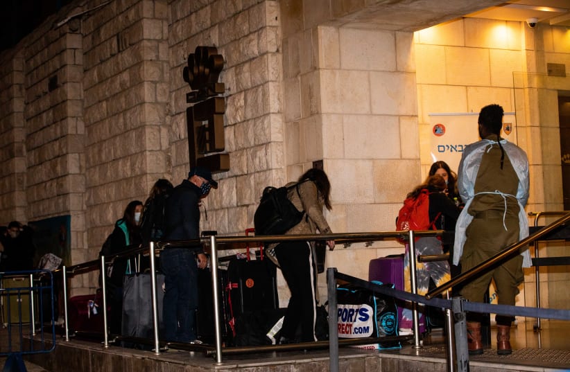 People who arrived on a flight from England arrive to the Dan Panorama Hotel used as a quarantine facility, on December 20, 2020.  (photo credit: YONATAN SINDEL/FLASH 90)