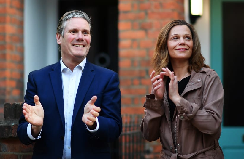 UK Labour leader Keir Starmer and his wife Victoria Starmer applaud for healthcare workers outside their home in London, May 14, 2020. (photo credit: JUSTIN SETTERFIELD/GETTY IMAGES)