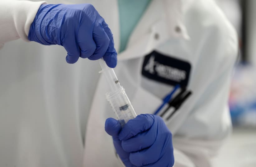 A scientist conducts research on a vaccine for the novel coronavirus (COVID-19) at the laboratories of RNA medicines company Arcturus Therapeutics in San Diego, California, U.S., March 17, 2020.  (photo credit: BING GUAN/REUTERS)