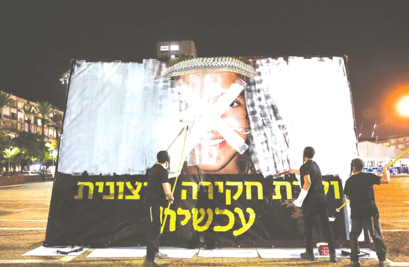 DEMONSTRATORS PAINT over a picture of Ahuvia Sandak in protest against his death, at Rabin Square in Tel Aviv on Tuesday. (photo credit: MIRIAM ALSTER/FLASH90)
