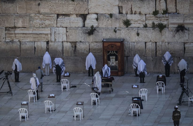 A small group of socially distanced kohens, or Jewish high priests, take part in Passover prayers by the Western Wall, April 12, 2020. (photo credit: ILIA YEFIMOVICH/PICTURE ALLIANCE VIA GETTY IMAGES)
