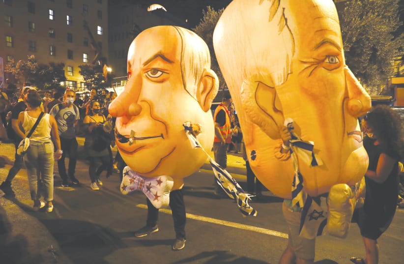INFLATABLE COSTUMES depict Prime Minister Benjamin Netanyahu and his main coalition partner, Defense Minister Benny Gantz, at a demonstration in Jerusalem in August. (photo credit: AMMAR AWAD/REUTERS)
