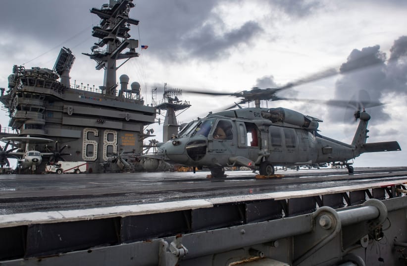 An MH-60S Sea Hawk helicopter conducts flight control checks on the flight deck of the U.S. Navy aircraft carrier USS Nimitz in the Indian Ocean November 25, 2020. Picture taken November 25, 2020 (photo credit: U.S. NAVY/MASS COMMUNICATION SPECIALIST 3RD CLASS ELLIOT SCHAUDT/HANDOUT VIA REUTERS)
