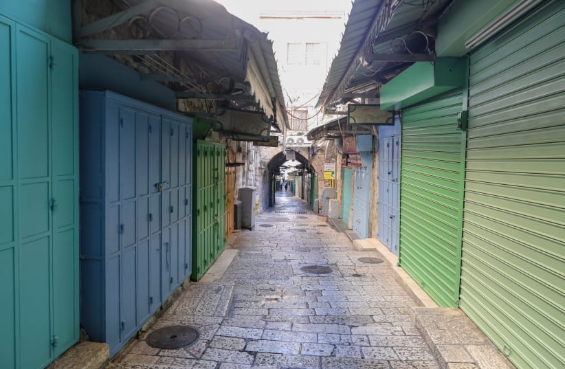 Stores are seen shuttered closed and streets are empty in Jerusalem's Old City amid Israel's third coronavirus lockdown, on January 4, 2021. (photo credit: MARC ISRAEL SELLEM/THE JERUSALEM POST)