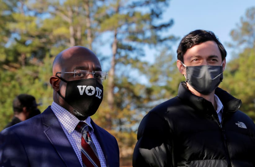 Democratic US Senate candidates Jon Ossoff and Rev. Raphael Warnock look on as they appear together at a campaign rally ahead of US Senate runoff elections in Augusta, Georgia, US, January 4, 2021. (photo credit: REUTERS/MIKE SEGAR)