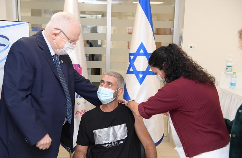 President Reuven Rivlin is seen alongside the first person to receive the second dose of the Israel-made coronavirus vaccine at Ashkelon's Barzilai Medical Center. (photo credit: AMOS BEN-GERSHOM/GPO)