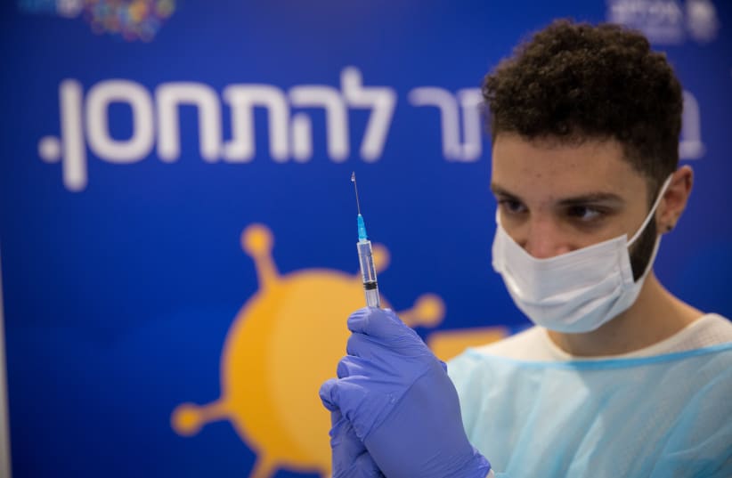 A healthcare worker prepares a vaccine at a facility operated by the Tel Aviv Sourasky Medical Center in Rabin Square, Dec. 31, 2020. (photo credit: MIRIAM ASTER/FLASH90)